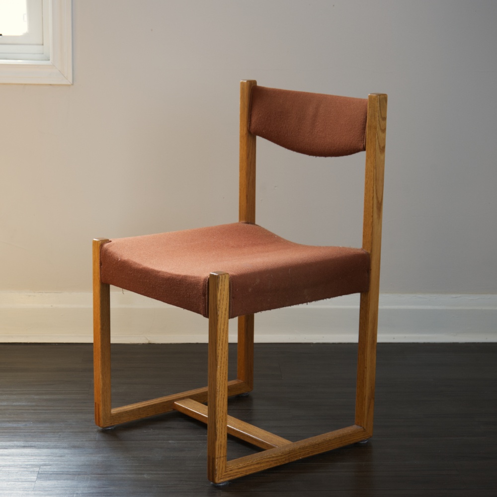 A wood chair in a room.